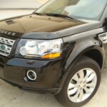 Before and after photographs of a damaged, black, Range Rover that was repaired by Elite Paint & Body Shop in West Palm Beach, FL.